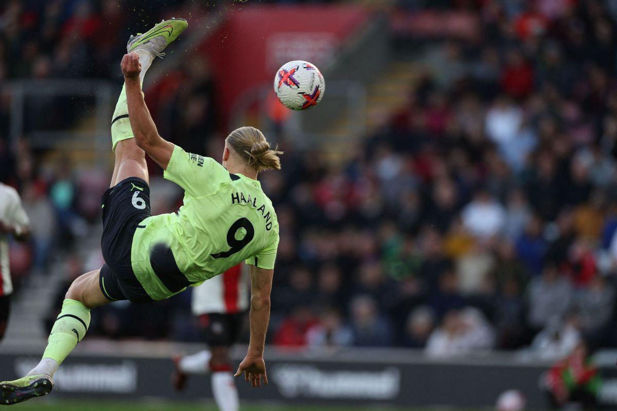 Soccer player in mid-air kicking a ball with a blurred crowd in the background. erling haaland beetroot powder
