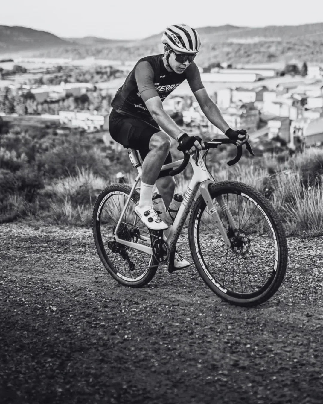 Person cycling on a dirt road with a scenic background. Close-up of a cyclist pedaling on a white bicycle with 'P2' branding. stamox beetroot powder
