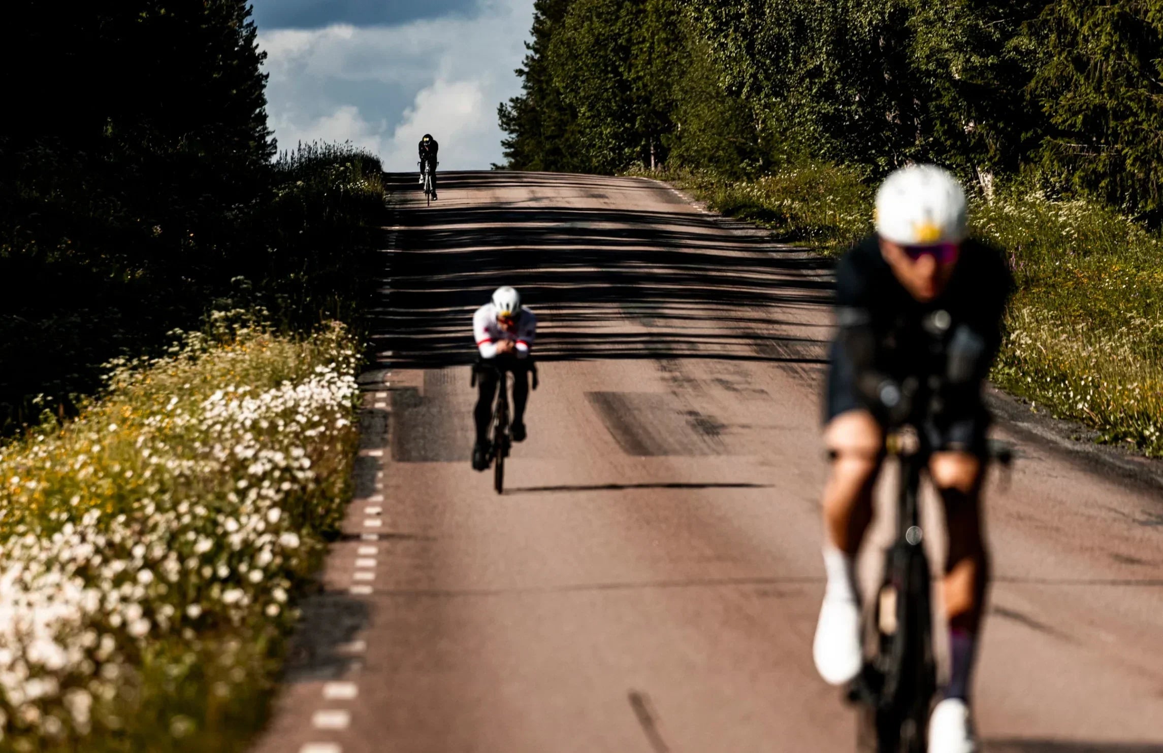 Cyclists racing on a sunny rural road, highlighting stamina and stamox beetroot powder benefits