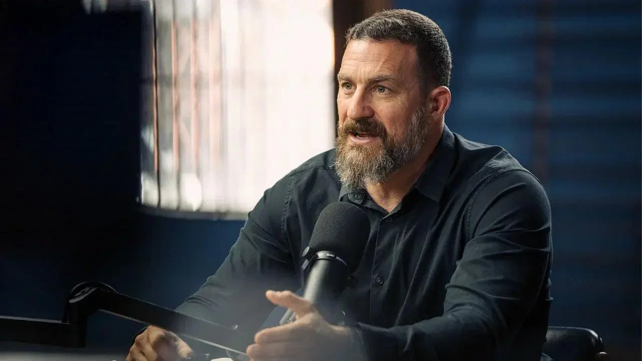 Man with a beard speaking into a microphone in a dark room. stamox beetroot powder dr. andrew huberman podcast