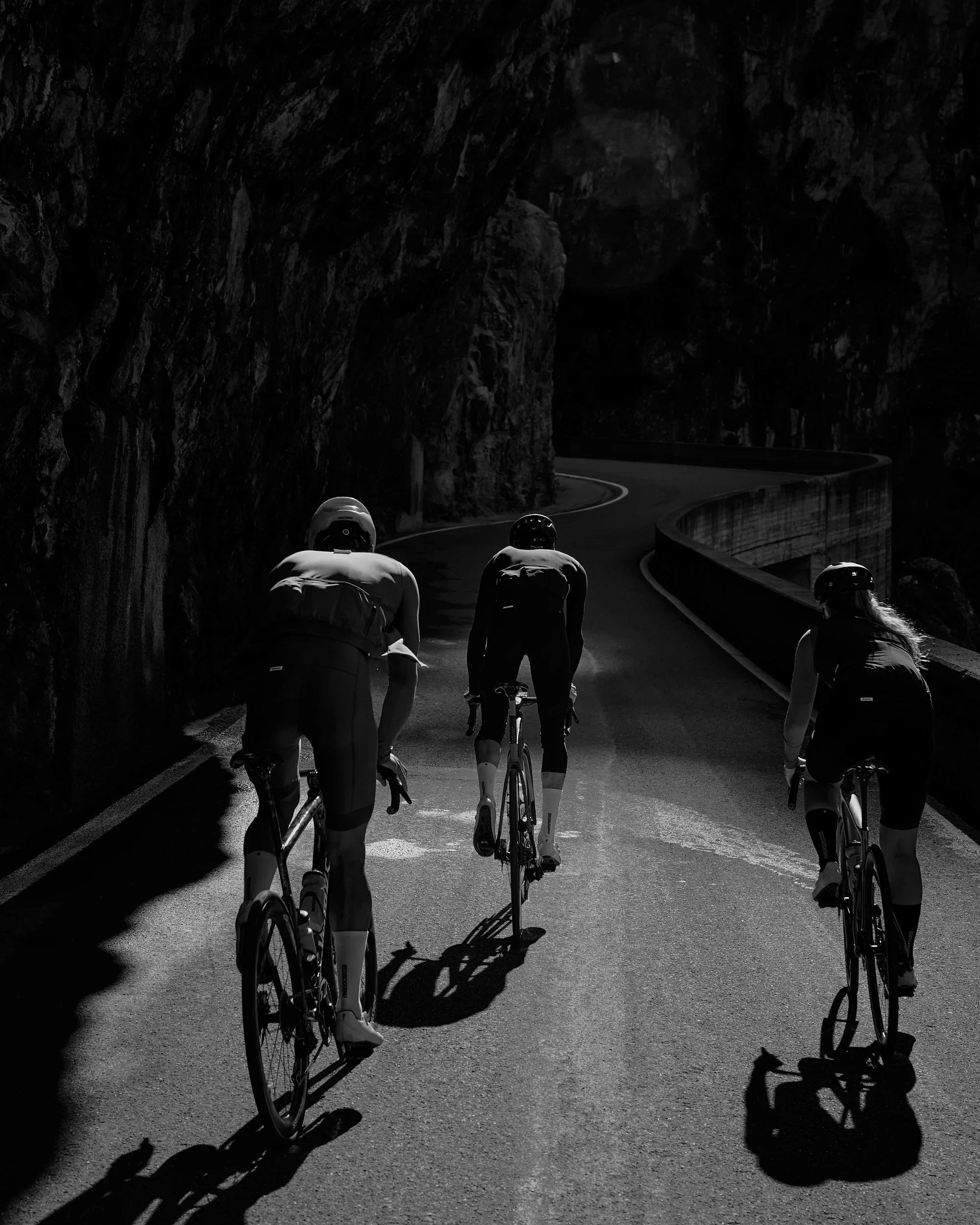 Cyclists riding uphill in a mountain tunnel, endurance boosted by stamox beetroot powder