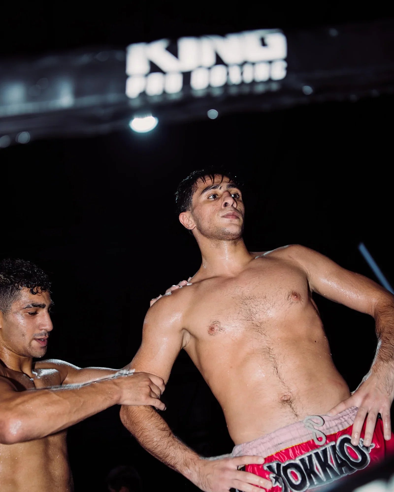 Boxer training with partner under King Pro Boxing sign, fueled by Stamox beetroot powder for endurance & recovery