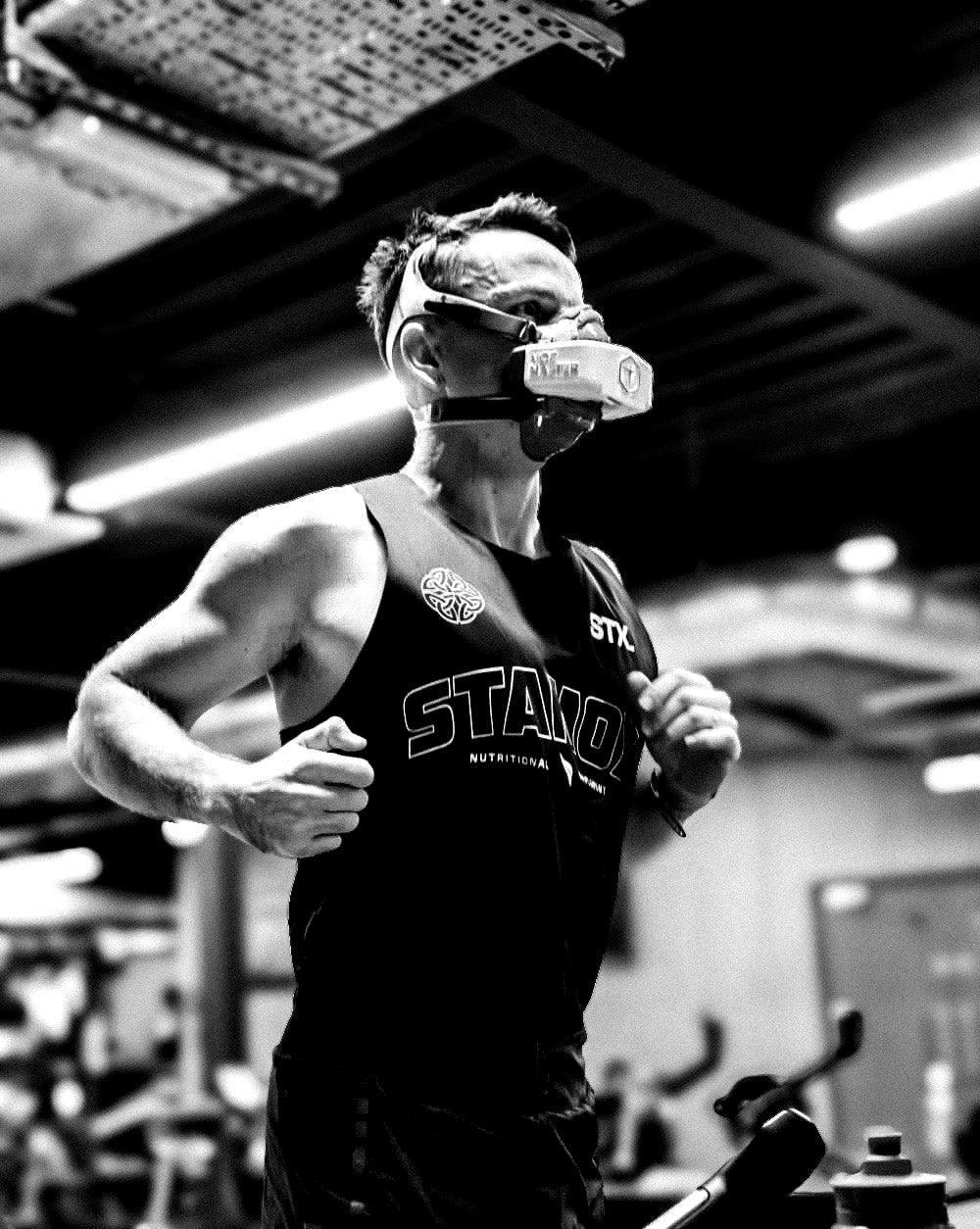 Person wearing a tank top with 'STX STAMOX NUTRITION' branding in a gym setting. vo2 max