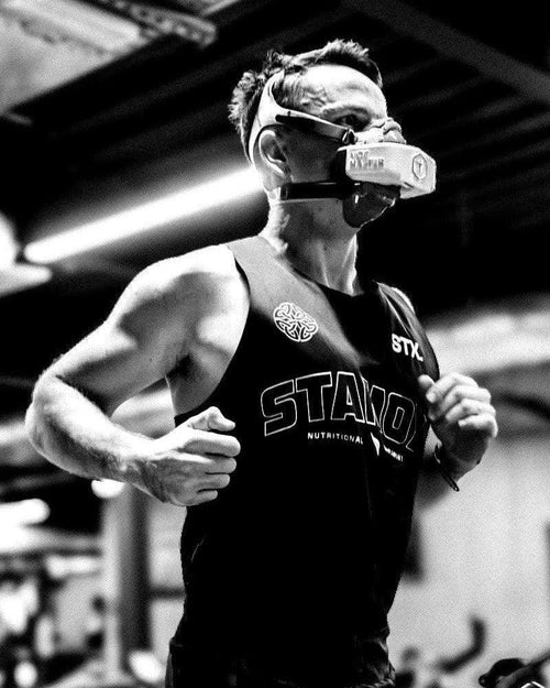 Athlete running indoors wearing STAMOX shirt and training mask, stamox beetroot powder