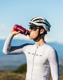 Cyclist drinks from Stamox bottle outdoors, promoting Stamox beetroot powder benefits.