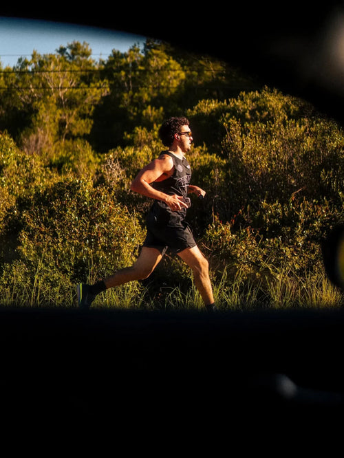 Athlete running outdoors in sunlight, showcasing stamina from Stamox beetroot powder