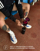 Athlete preparing stamox beetroot powder supplement with water before training on track