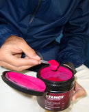 Hand scooping Stamox beetroot powder from container, natural supplement for endurance