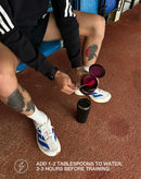Athlete scooping stamox beetroot powder into a shaker before workout on running track
