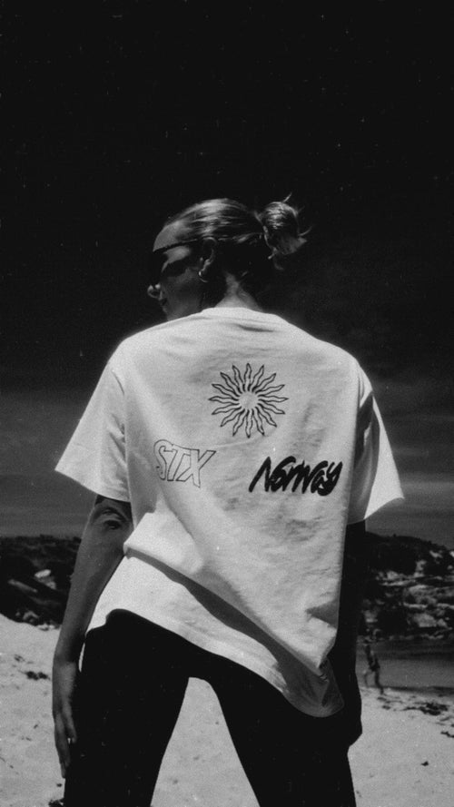 Person on beach wearing sunglasses and white t-shirt, promoting Stamox Beetroot Powder