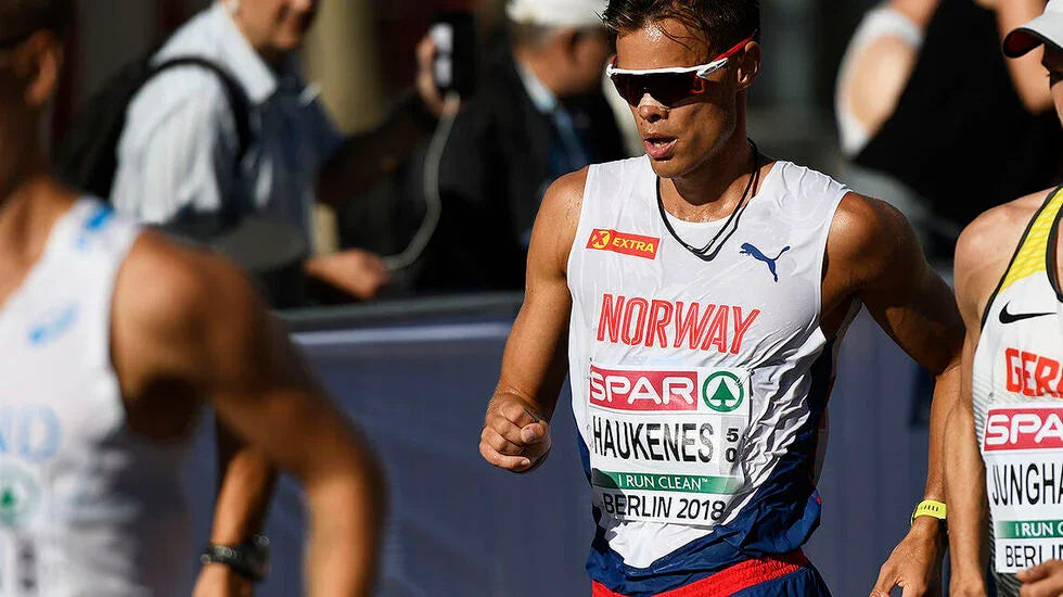 Athlete running in a race with 'Norway' and 'Spar' branding on their shirt.
