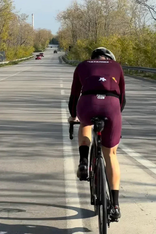 Cyclist in Stamox branded gear riding on road, promoting stamox beetroot powder for endurance