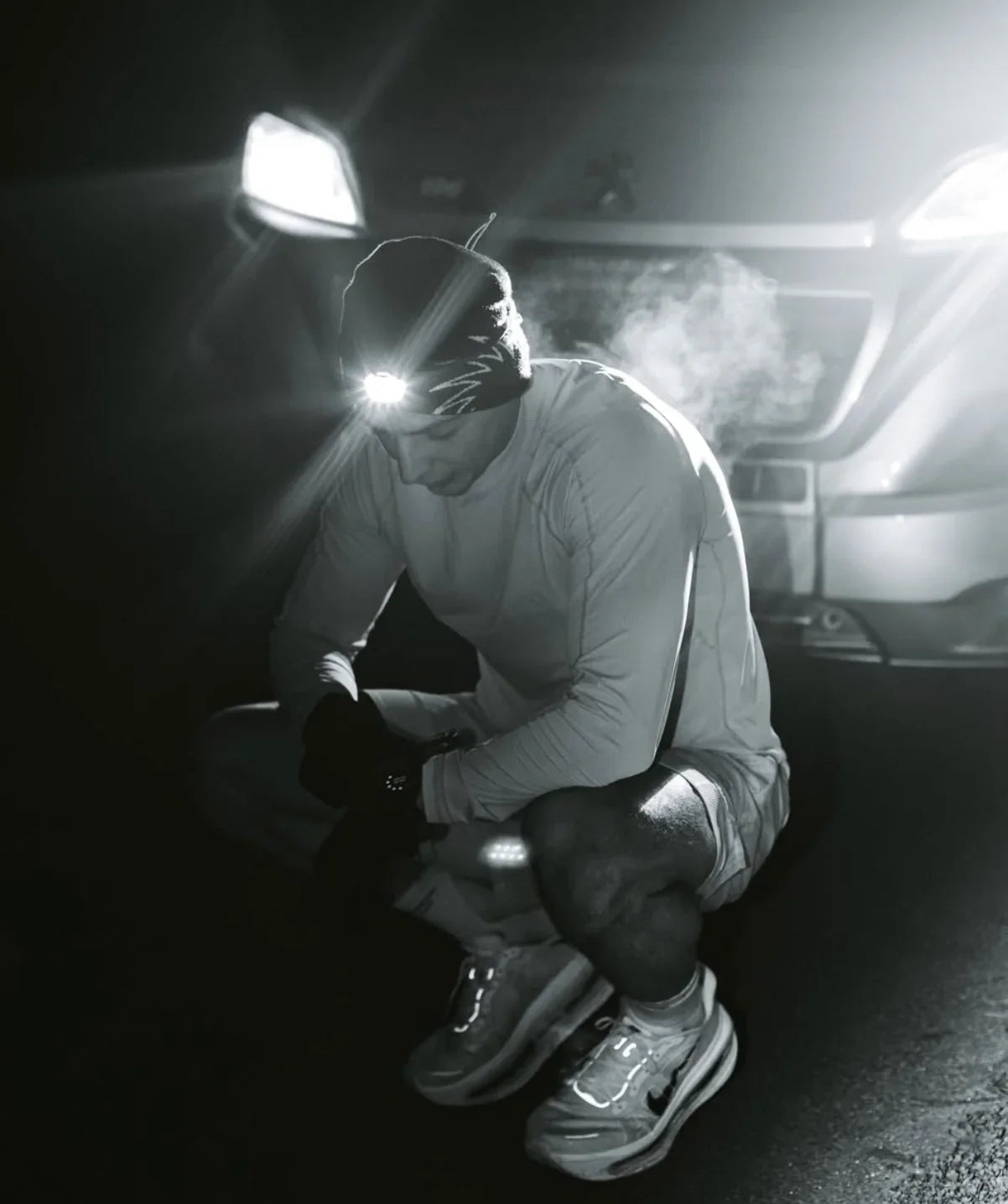 Athlete resting at night by car with headlamp, showcasing stamox beetroot powder for endurance