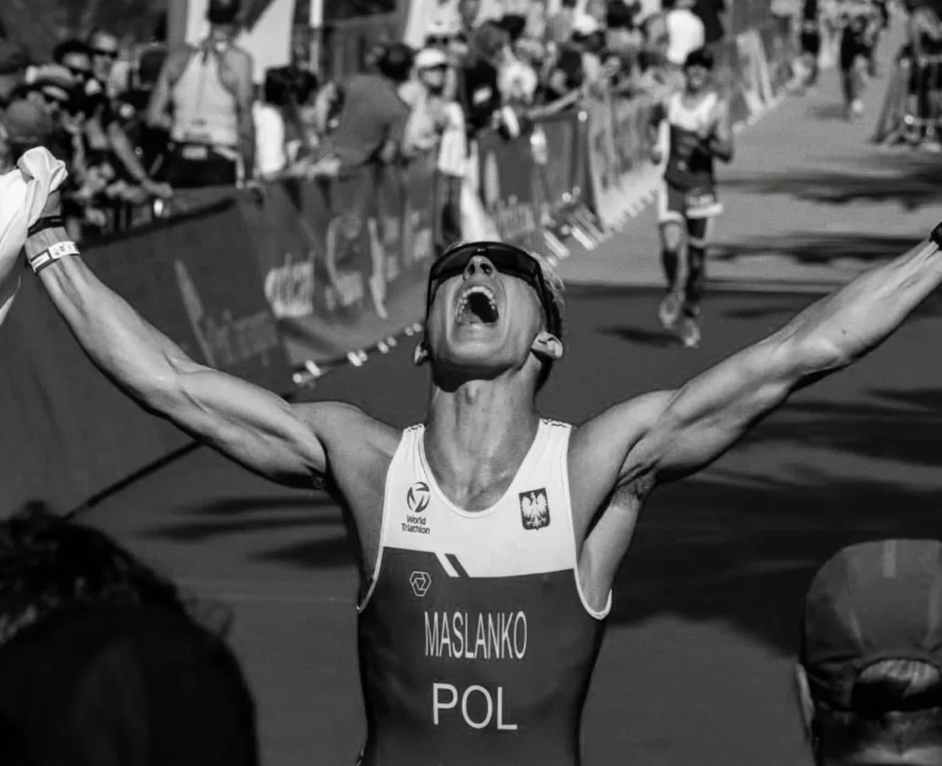 Triathlete celebrating victory with arms raised, powered by Stamox beetroot powder for endurance and recovery.