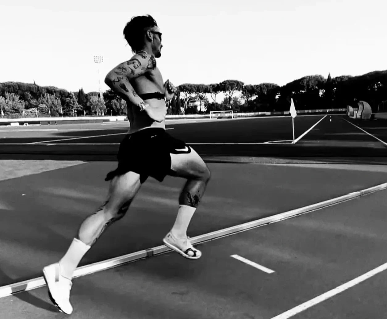 Person running on a track with trees in the background