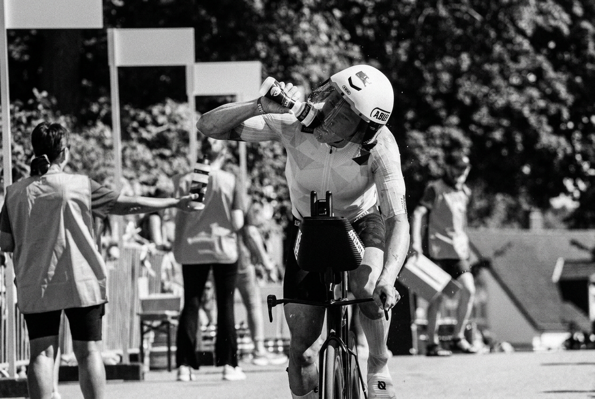 Cyclist in helmet drinking stamox beetroot sport nutrition for vo2 max during a race.