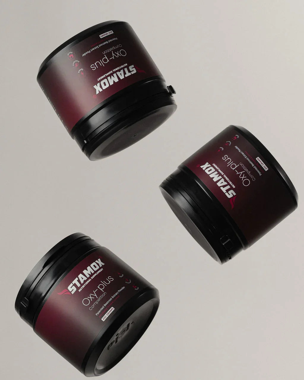 Stamox beetroot powder jars in black containers with red labels, showcasing Oxy-Plus composition for endurance and recovery.