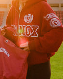 person wearing red hoodie and holding bag at stadium, stamox beetroot powder keywords