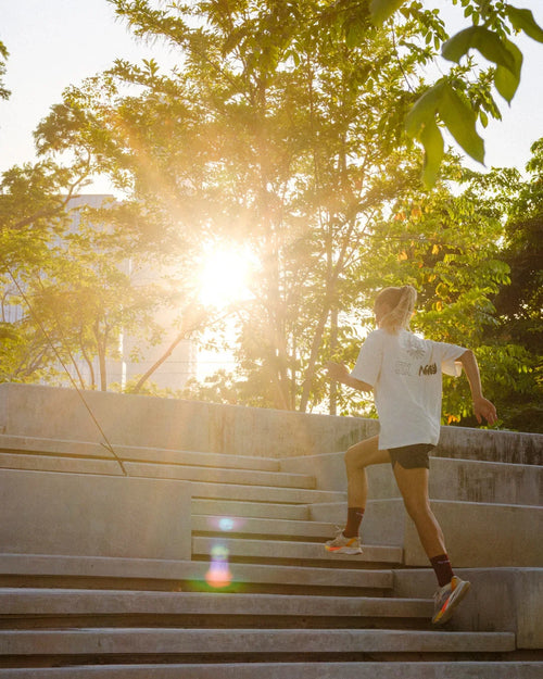 Runner training outdoors on sunny stairs, powered by stamox beetroot powder for endurance