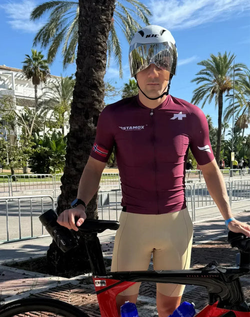 Cyclist in Stamox jersey posing with bike, promoting Stamox beetroot powder outdoors.