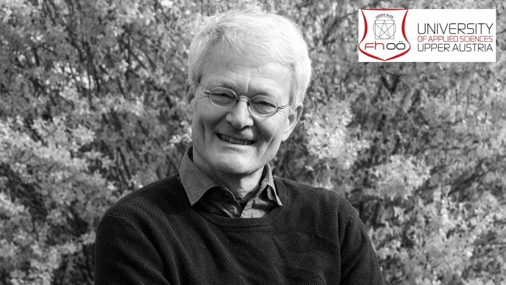 Smiling man outdoors, black and white, with University of Applied Sciences Upper Austria logo, stamox beetroot powder
