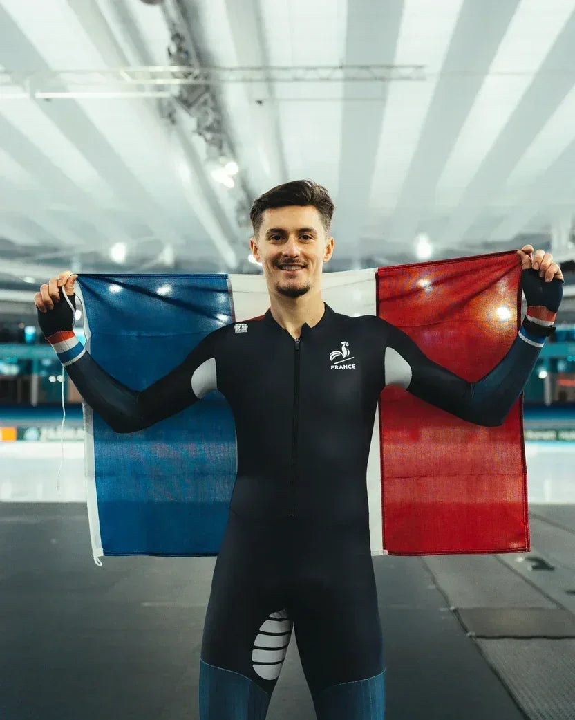 Athlete holding French flag, powered by Stamox beetroot powder for endurance and recovery.
