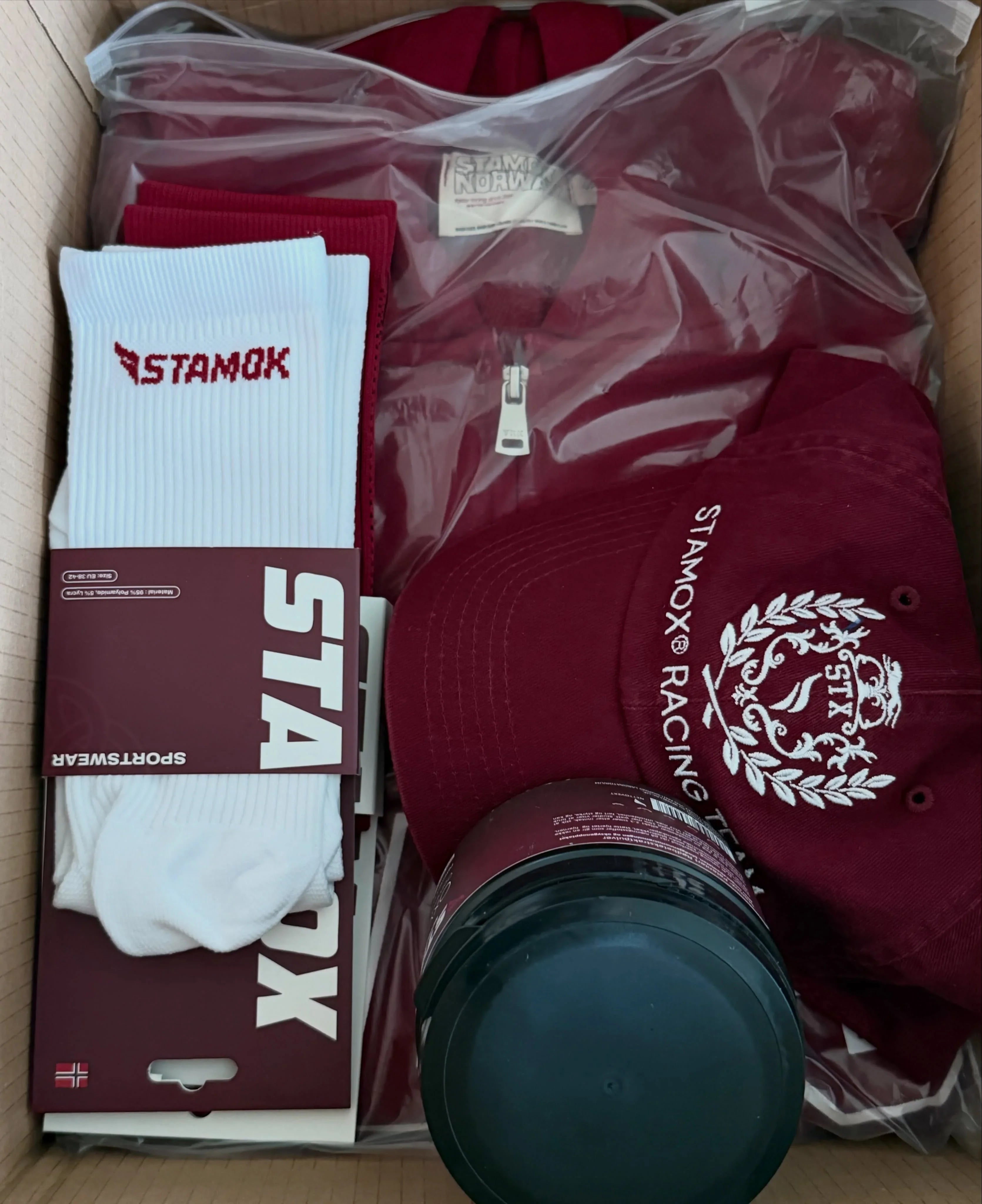 Stamox beetroot sport nutrition VO2 max kit with red cap, hoodie, and white socks in a box.
