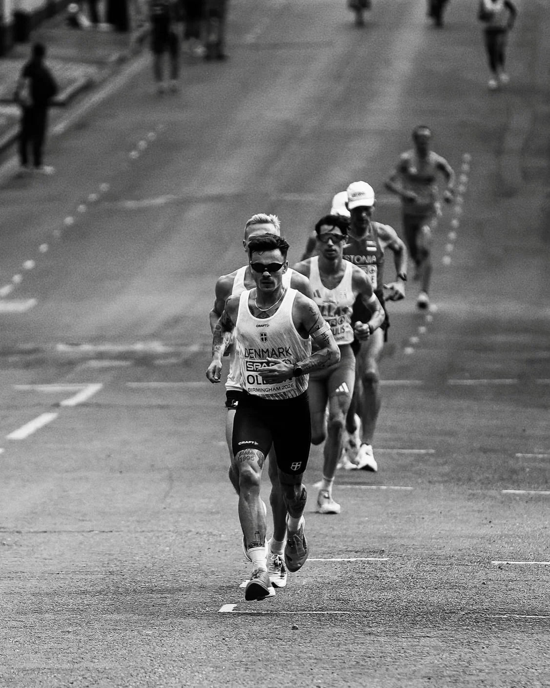 Athletes running in a race, showcasing endurance and power on the track.