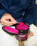 Hand scooping bright red stamox beetroot powder from oxy-plus supplement container