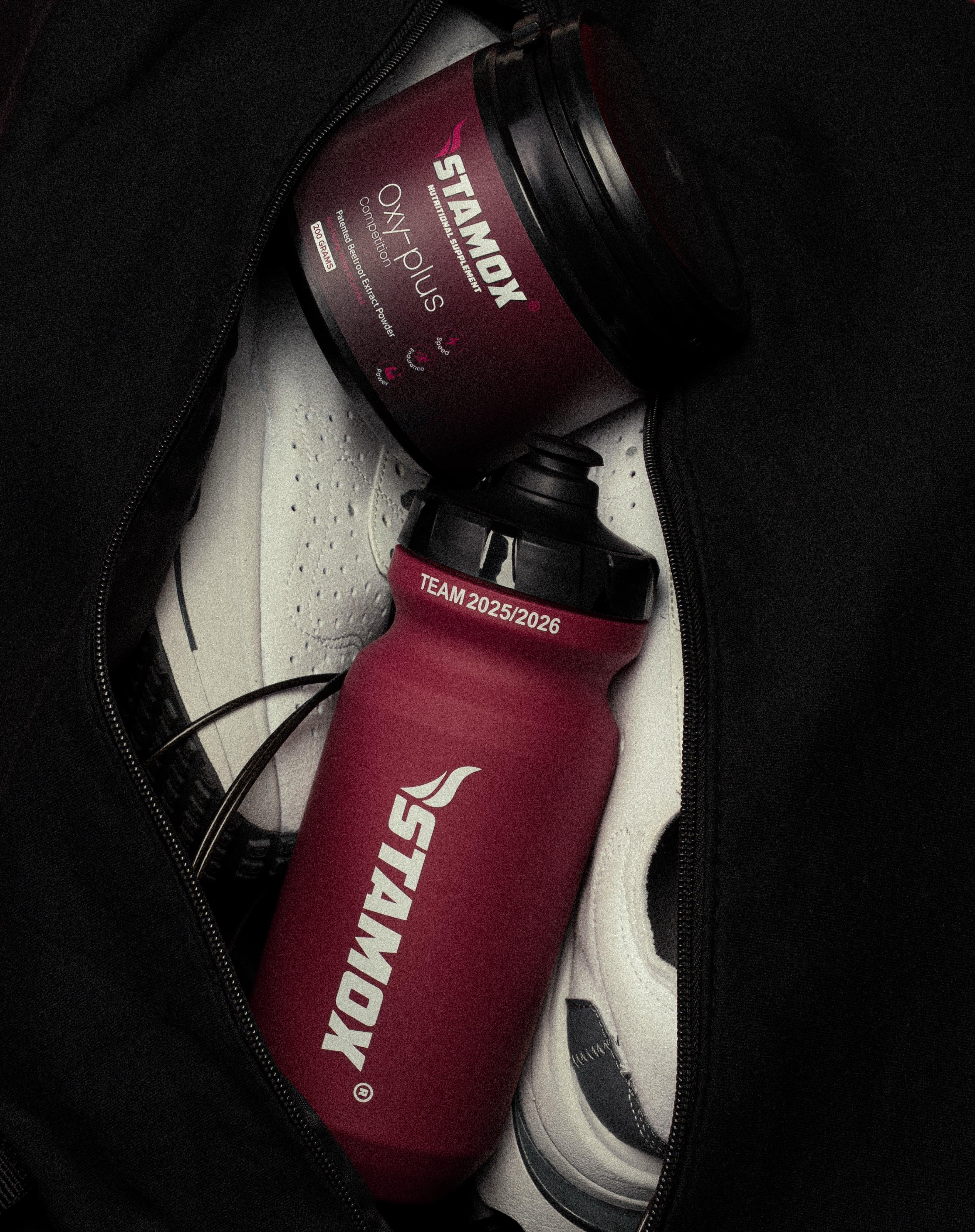 Stamox beetroot powder container and sports bottle in gym bag with sneakers