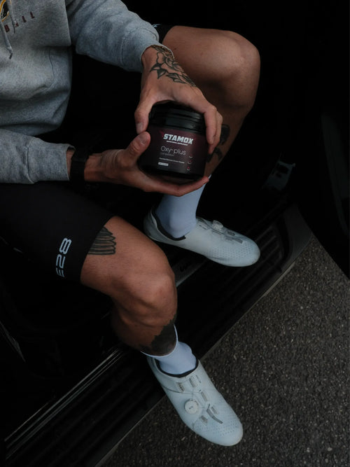 Athlete holding beetroot extract powder supplement for endurance and recovery, wearing cycling gear