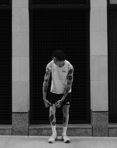 Athlete wearing Stamox vest and shorts standing outside, promoting stamox beetroot powder