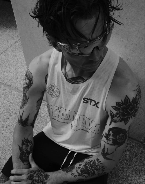 Tattooed athlete in Stamox vest promoting Stamox beetroot powder for endurance boost