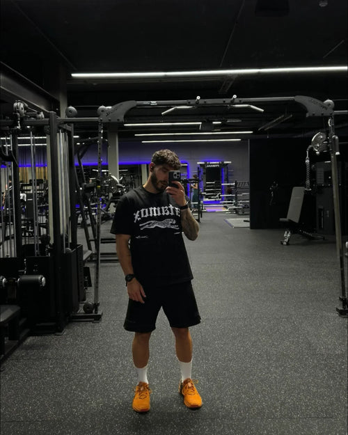 Man taking selfie in gym with fitness equipment, stamox beetroot powder lifestyle