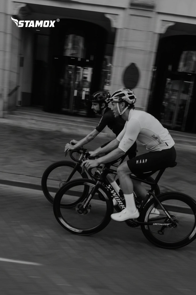 Two cyclists racing on road bikes, stamox beetroot powder for endurance and performance